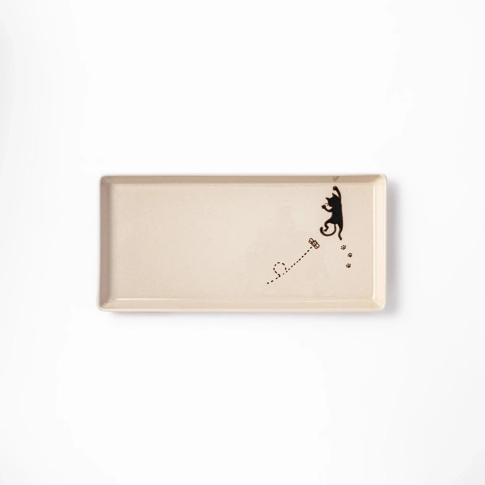 Beige rectangular ceramic plate featuring a playful black cat illustration with paw prints and a butterfly in the corner.