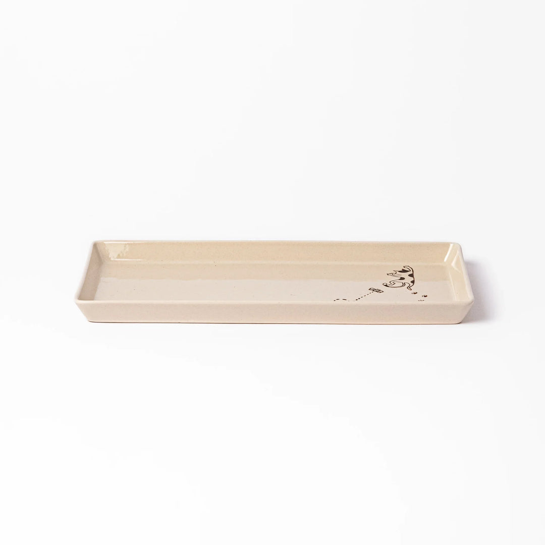 Beige rectangular ceramic plate featuring a playful calico cat illustration with paw prints and a butterfly in the corner.