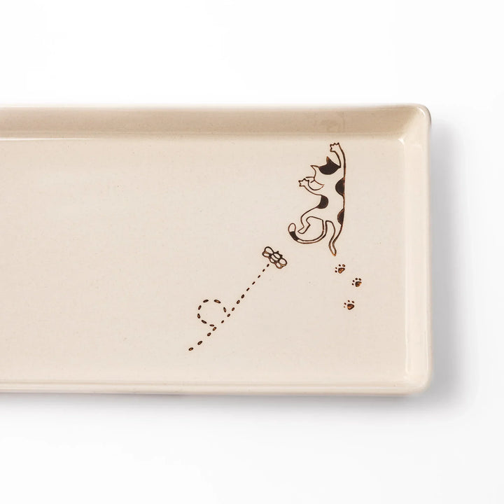 Beige rectangular ceramic plate featuring a playful calico cat illustration with paw prints and a butterfly in the corner.