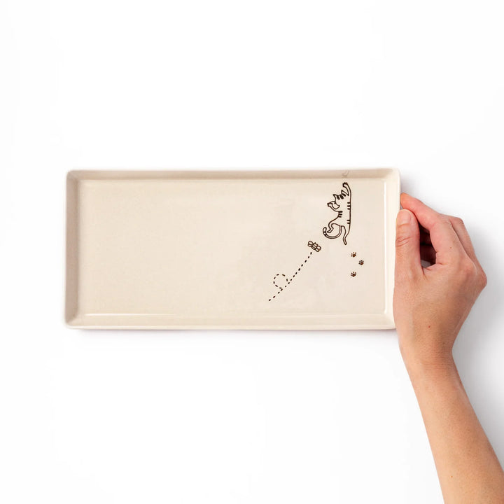Beige rectangular ceramic plate featuring a playful tabby cat illustration with paw prints and a butterfly in the corner.