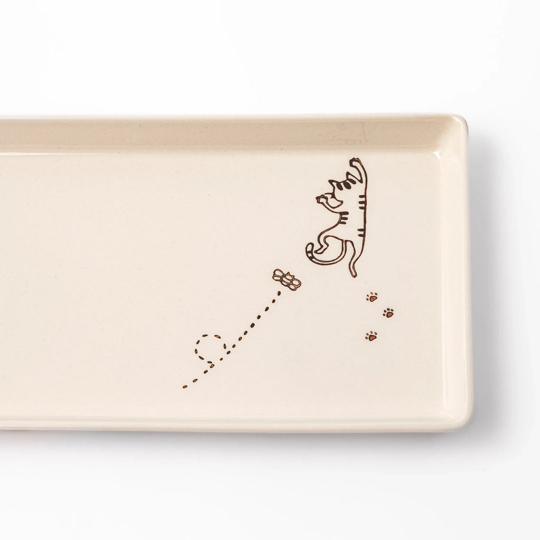 Beige rectangular ceramic plate featuring a playful tabby cat illustration with paw prints and a butterfly in the corner.