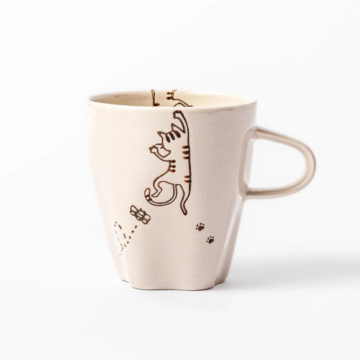 Cream-colored cup with a striped cat design reaching toward a butterfly, with dotted lines and paw prints.