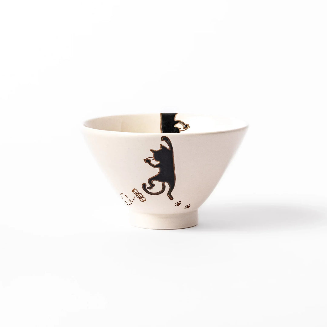 Cream-colored rice bowl with a black hanging cat, butterfly, and playful paw prints on the outside and inner rim.