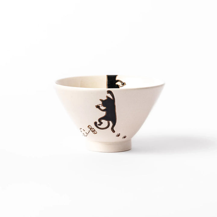 Cream-colored rice bowl with a black hanging cat, butterfly, and playful paw prints on the outside and inner rim.