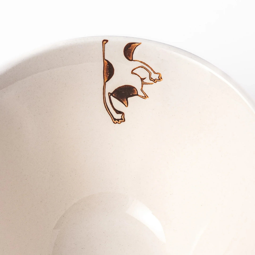 Cream-colored rice bowl with a calico hanging cat, butterfly, and playful paw prints on the outside and inner rim.