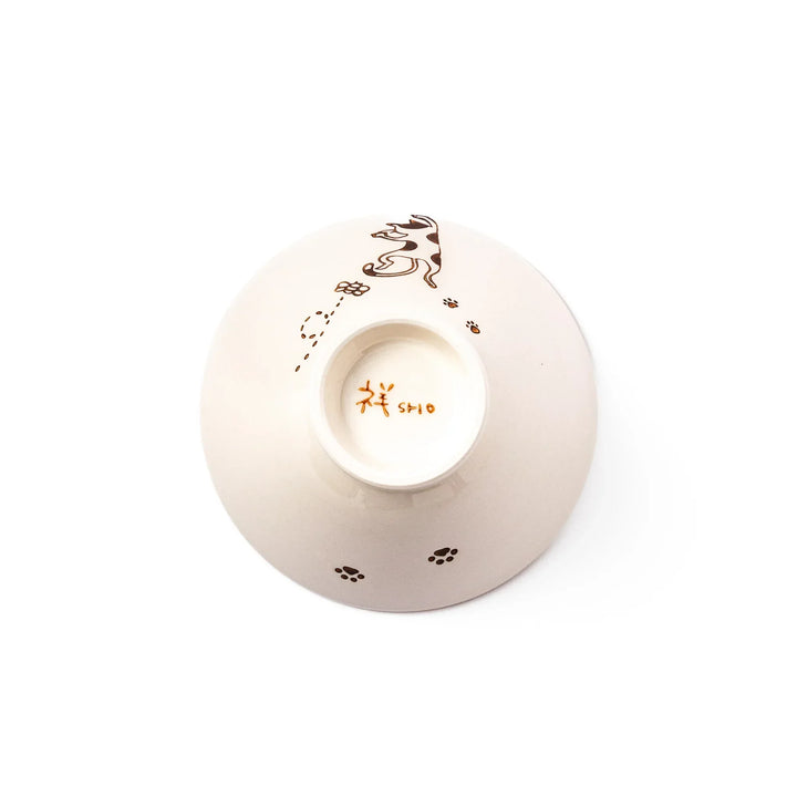 Cream-colored rice bowl with a calico hanging cat, butterfly, and playful paw prints on the outside and inner rim.