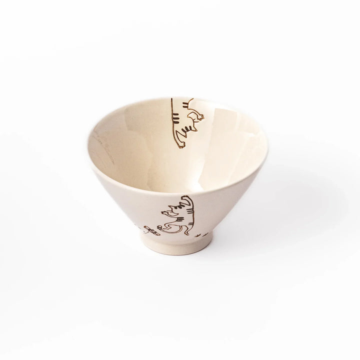 Cream-colored rice bowl with a striped hanging cat, butterfly, and dotted paw prints on the outer and inner surface.