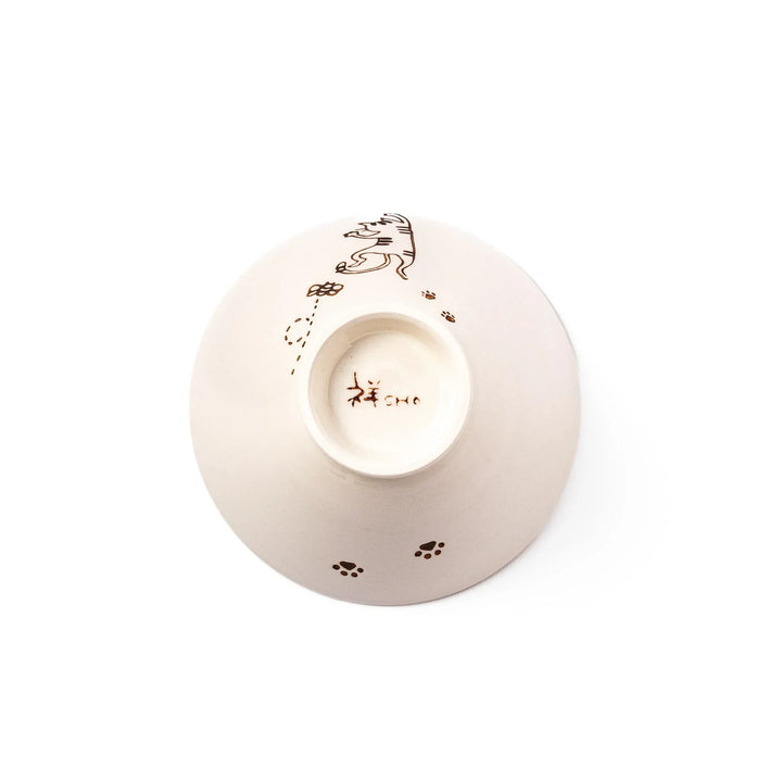 Cream-colored rice bowl with a striped hanging cat, butterfly, and dotted paw prints on the outer and inner surface.