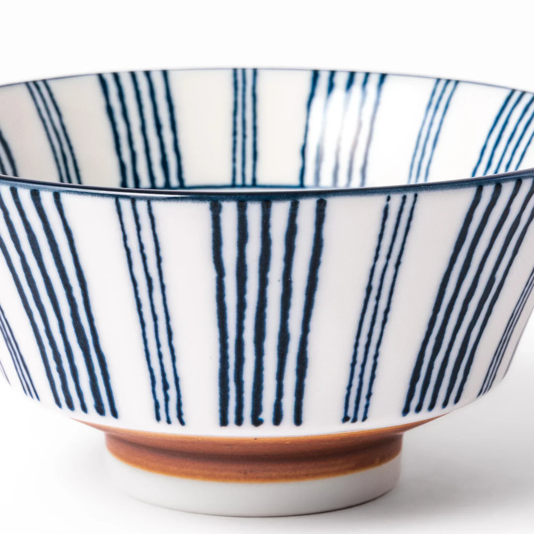 Japanese porcelain rice bowl with fine indigo vertical stripes and terracotta base in minimalist design.