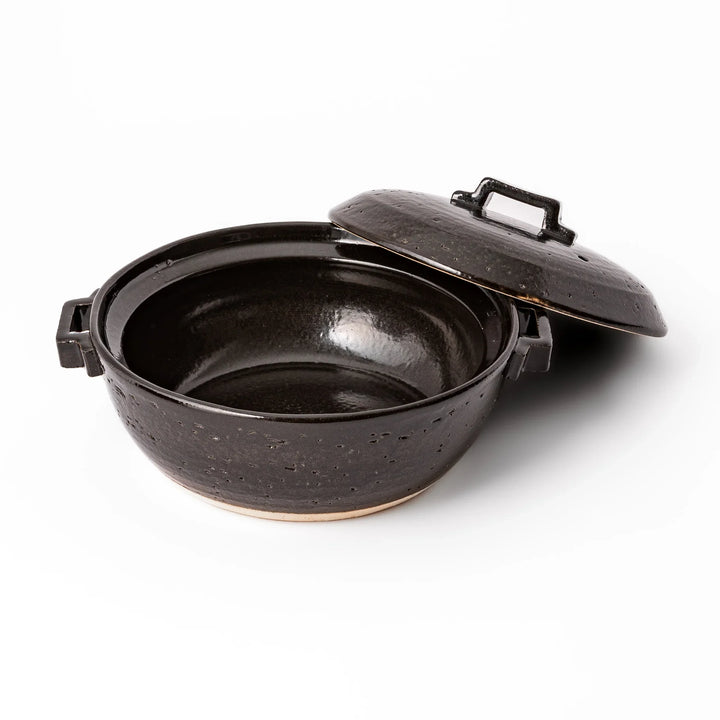 Black Japanese ceramic donabe pot with lid and side handles for simmering and hot pot cooking