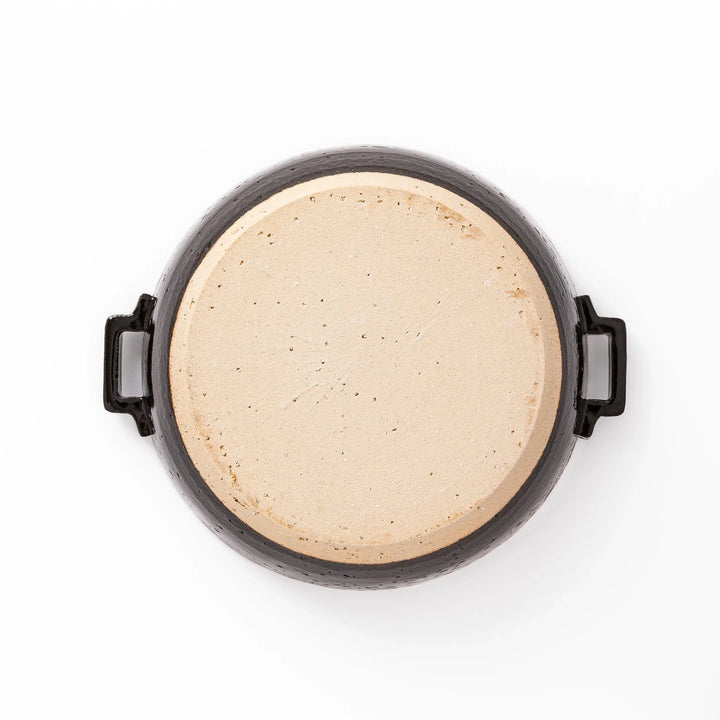 Black Japanese ceramic donabe pot with lid and side handles for simmering and hot pot cooking