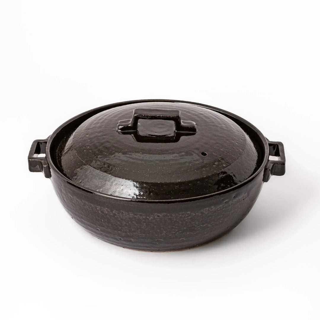 Black Japanese ceramic donabe with a fitted lid and side handles for family size hot pot and stovetop cooking