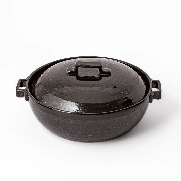 Black Japanese ceramic donabe with a fitted lid and side handles for family size hot pot and stovetop cooking