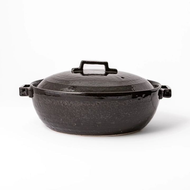 Black Japanese ceramic donabe with a fitted lid and side handles for family size hot pot and stovetop cooking