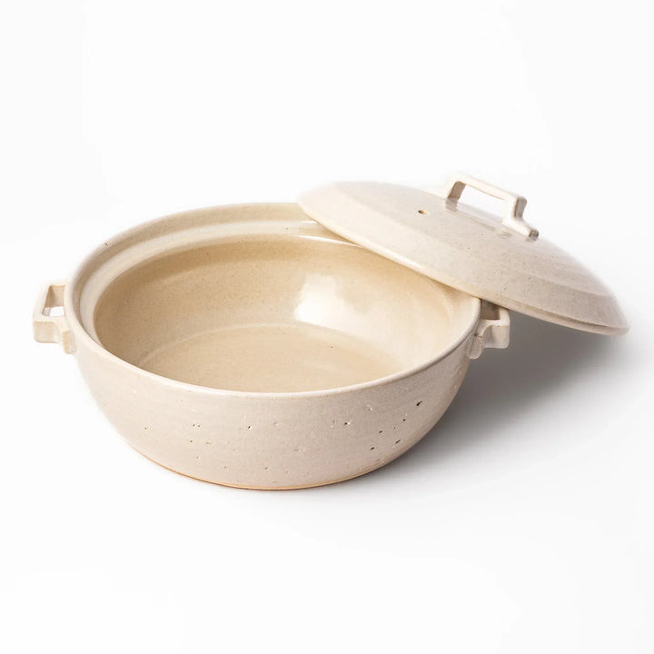 Beige Japanese ceramic family size donabe with a fitted lid and side handles for stovetop cooking and hot pot meals