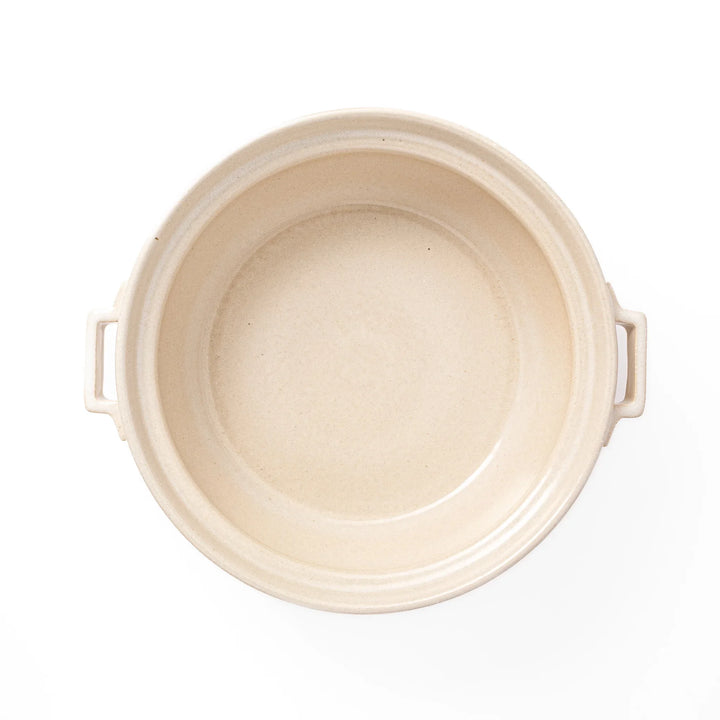 Beige Japanese ceramic family size donabe with a fitted lid and side handles for stovetop cooking and hot pot meals