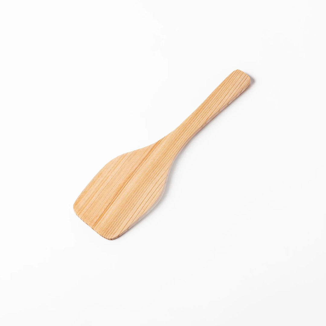 Compact hinoki wood spatula with flat angled edge and engraved handle for straining flipping and serving.