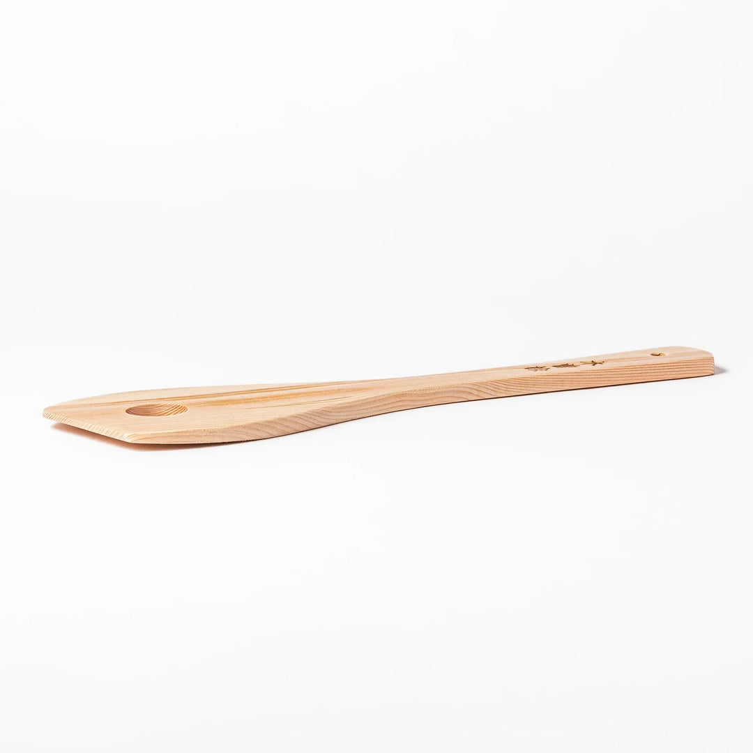 Hinoki wood slotted spatula with circular cutout and engraved handle for stirring and draining food.