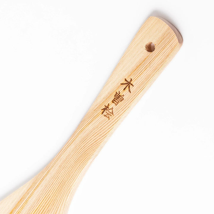 Hinoki wood slotted spatula with circular cutout and engraved handle for stirring and draining food.