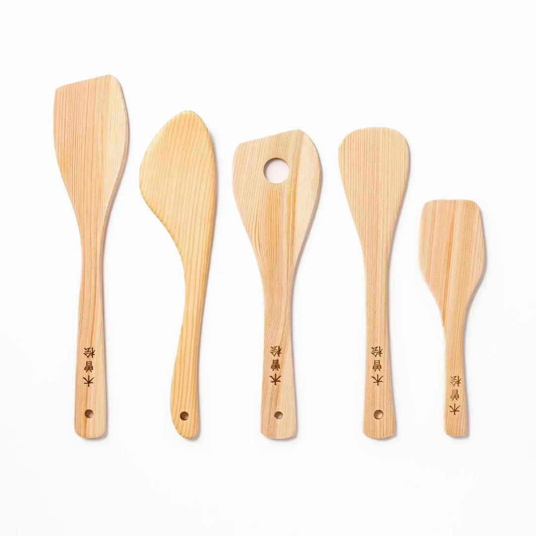 Hinoki wood spatula with engraved Japanese characters ideal for stir frying and gentle cooking on nonstick pans.
