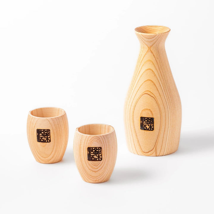 Hinoki wood sake set with carafe and two cups featuring burnt in designs for elegant Japanese sake rituals.