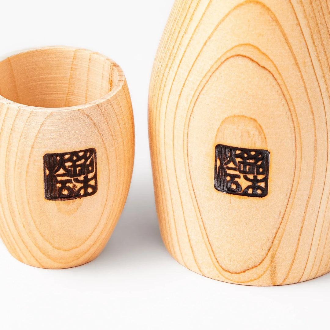 Hinoki wood sake set with carafe and two cups featuring burnt in designs for elegant Japanese sake rituals.
