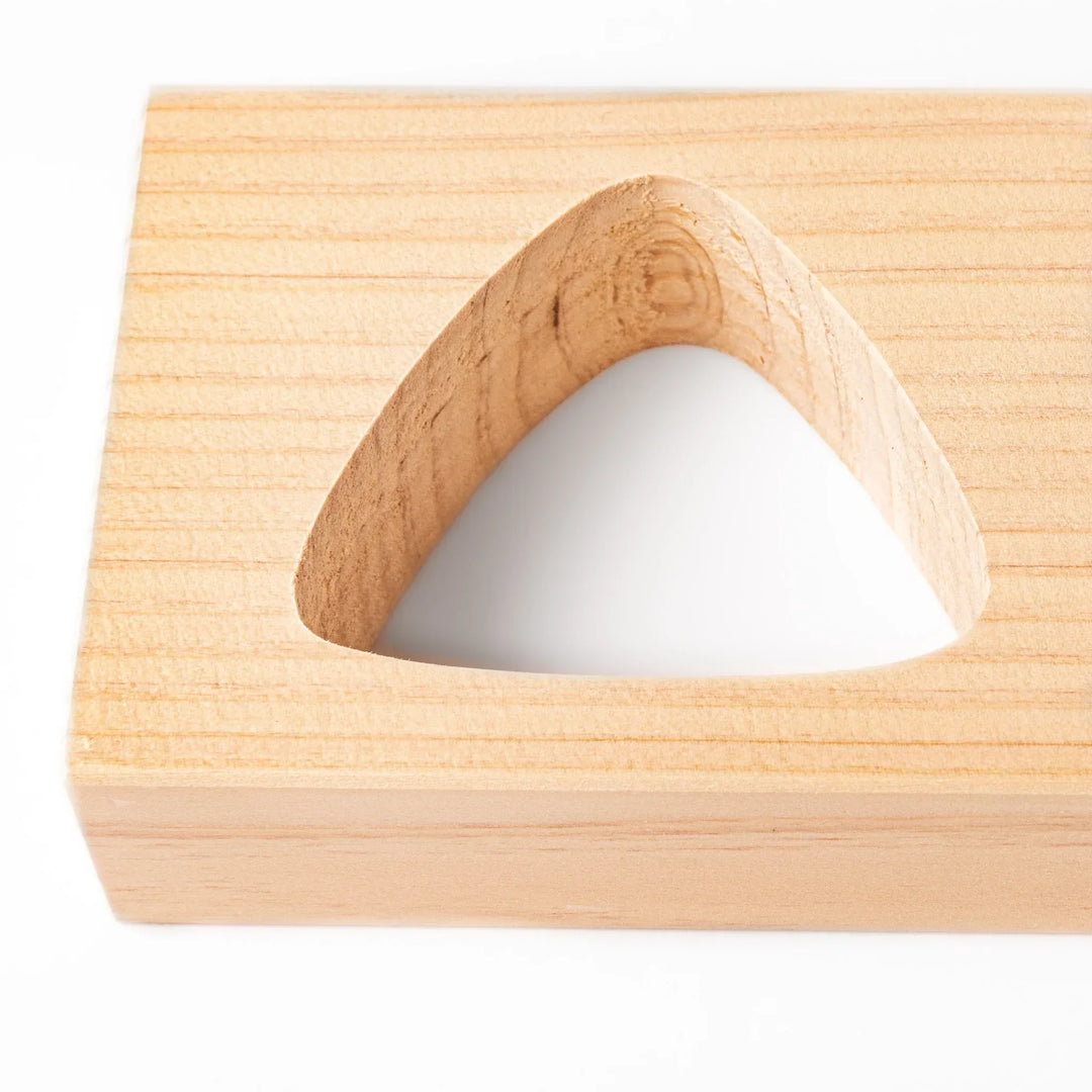 Hinoki wood onigiri mold with two triangle cavities and lid for shaping aromatic Japanese rice balls.
