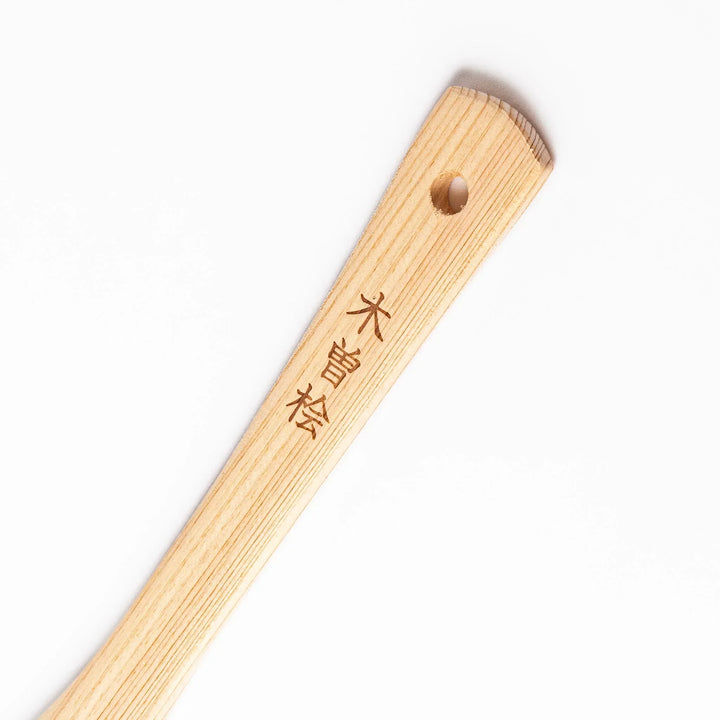 Lightweight hinoki wood spatula with fine grain and engraved Japanese handle for authentic kitchen use.