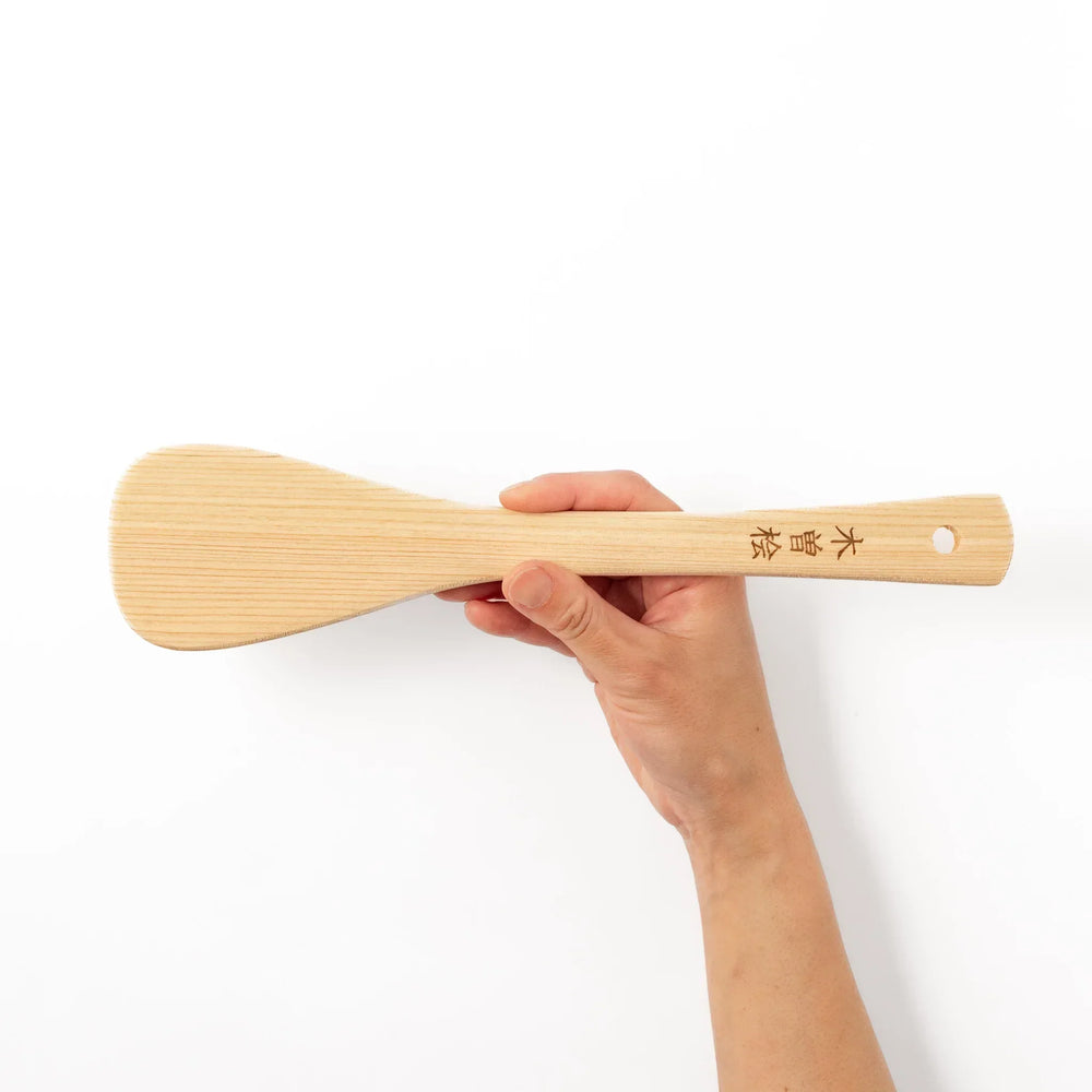 Lightweight hinoki wood spatula with fine grain and engraved Japanese handle for authentic kitchen use.