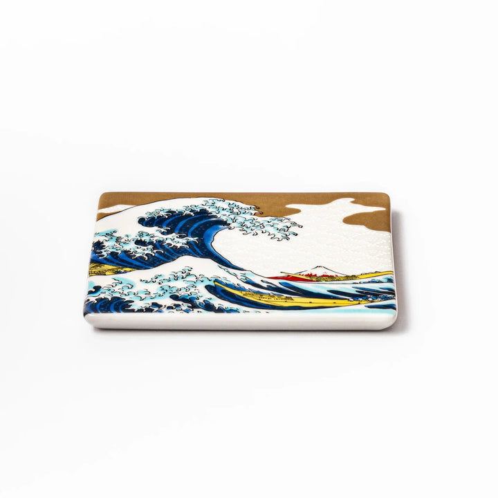 Square Japanese ceramic coaster with Hokusai Great Wave design featuring blue waves golden sky and Mt Fuji.