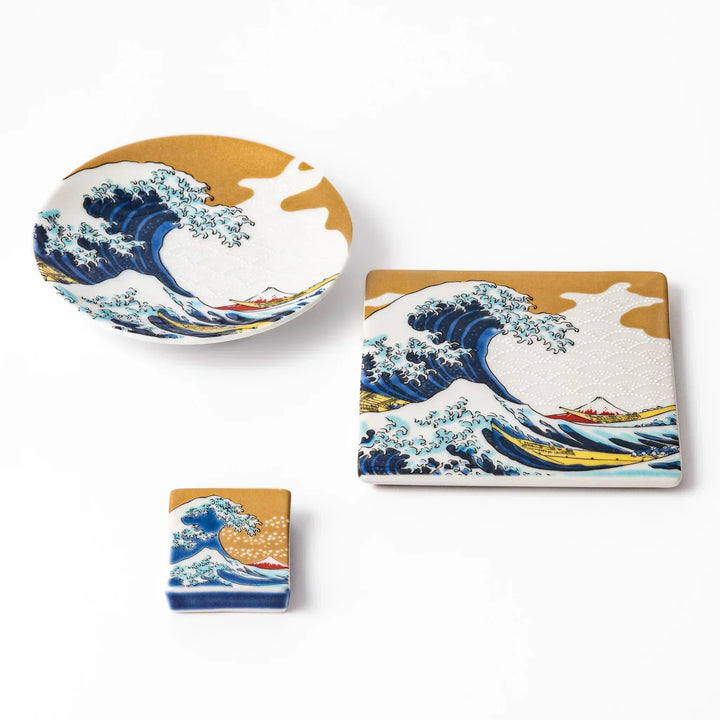 Japanese ceramic tableware set with Hokusai Great Wave design including dish coaster and chopstick rest.