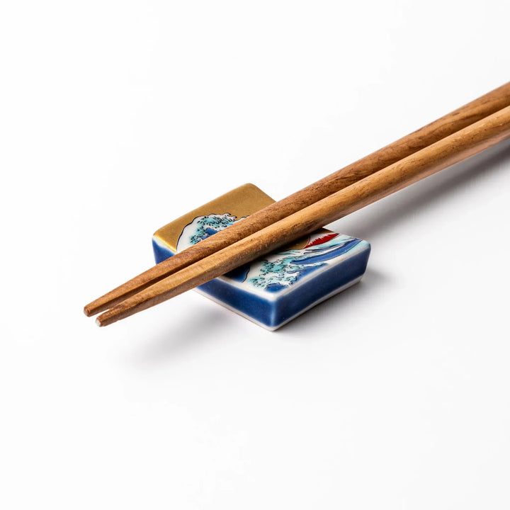 Rectangular Japanese ceramic chopstick rest with Hokusai Great Wave design blue wave golden sky Mt Fuji.