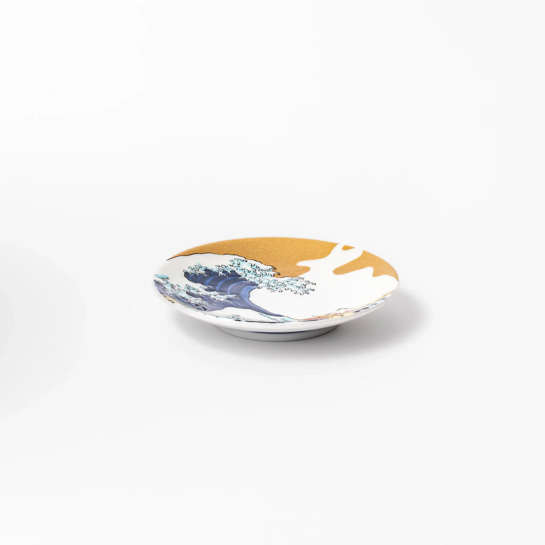 Round Japanese ceramic sauce dish with Hokusai Great Wave design showing blue waves golden sky and Mt Fuji.