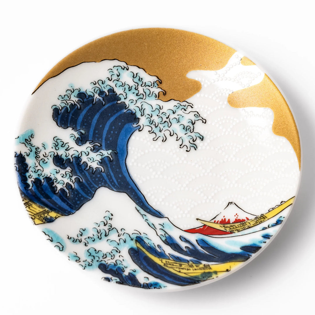 Round Japanese ceramic sauce dish with Hokusai Great Wave design showing blue waves golden sky and Mt Fuji.