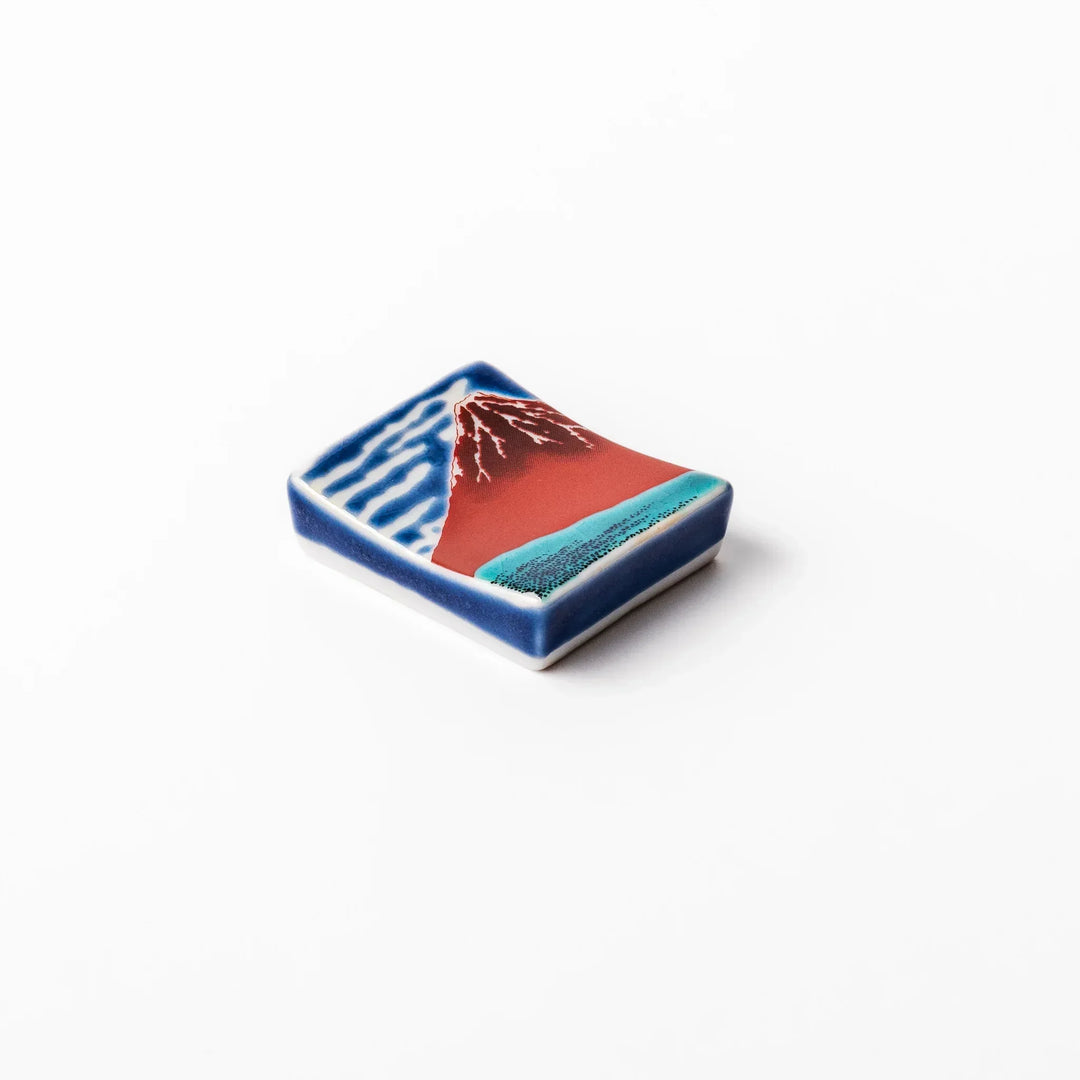 Rectangular Japanese ceramic chopstick rest with Hokusai Red Fuji design showing red mountain and blue sky.
