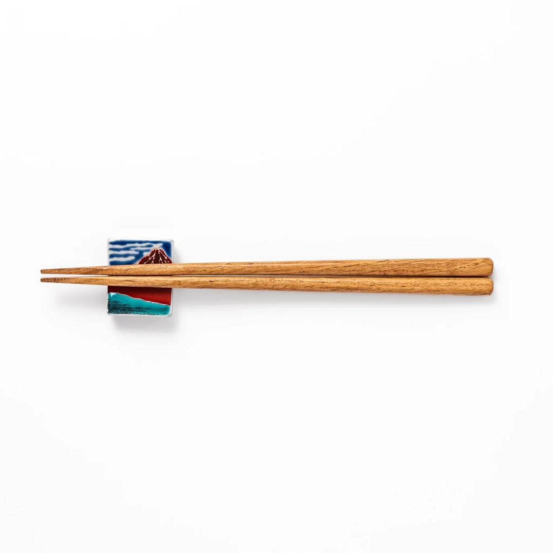 Rectangular Japanese ceramic chopstick rest with Hokusai Red Fuji design showing red mountain and blue sky.