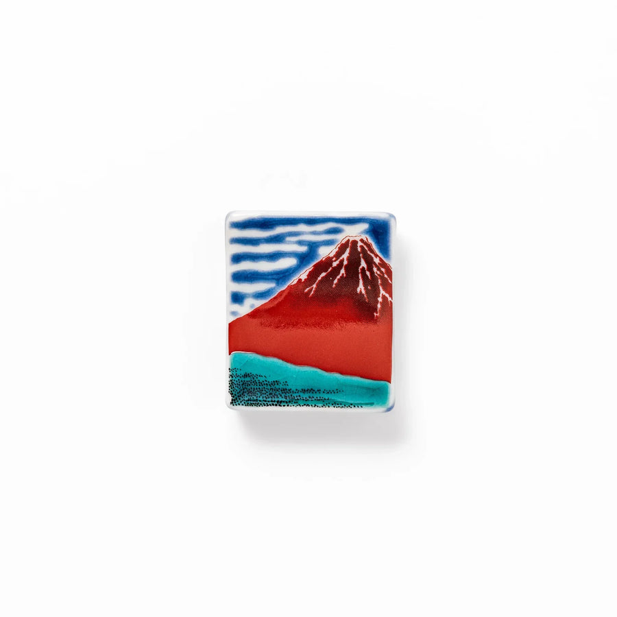 Rectangular Japanese ceramic chopstick rest with Hokusai Red Fuji design showing red mountain and blue sky.
