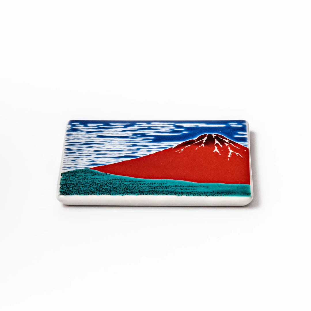 Square Japanese ceramic coaster with Hokusai Red Fuji design showing red mountain blue sky and white clouds.