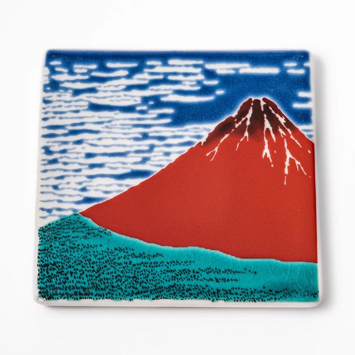Square Japanese ceramic coaster with Hokusai Red Fuji design showing red mountain blue sky and white clouds.