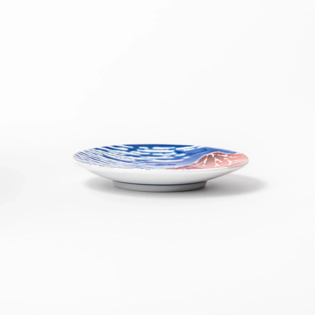 Round Japanese ceramic sauce dish with Hokusai Red Fuji design featuring red mountain blue sky and clouds.