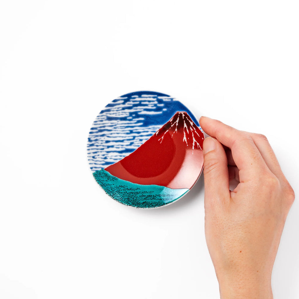Round Japanese ceramic sauce dish with Hokusai Red Fuji design featuring red mountain blue sky and clouds.