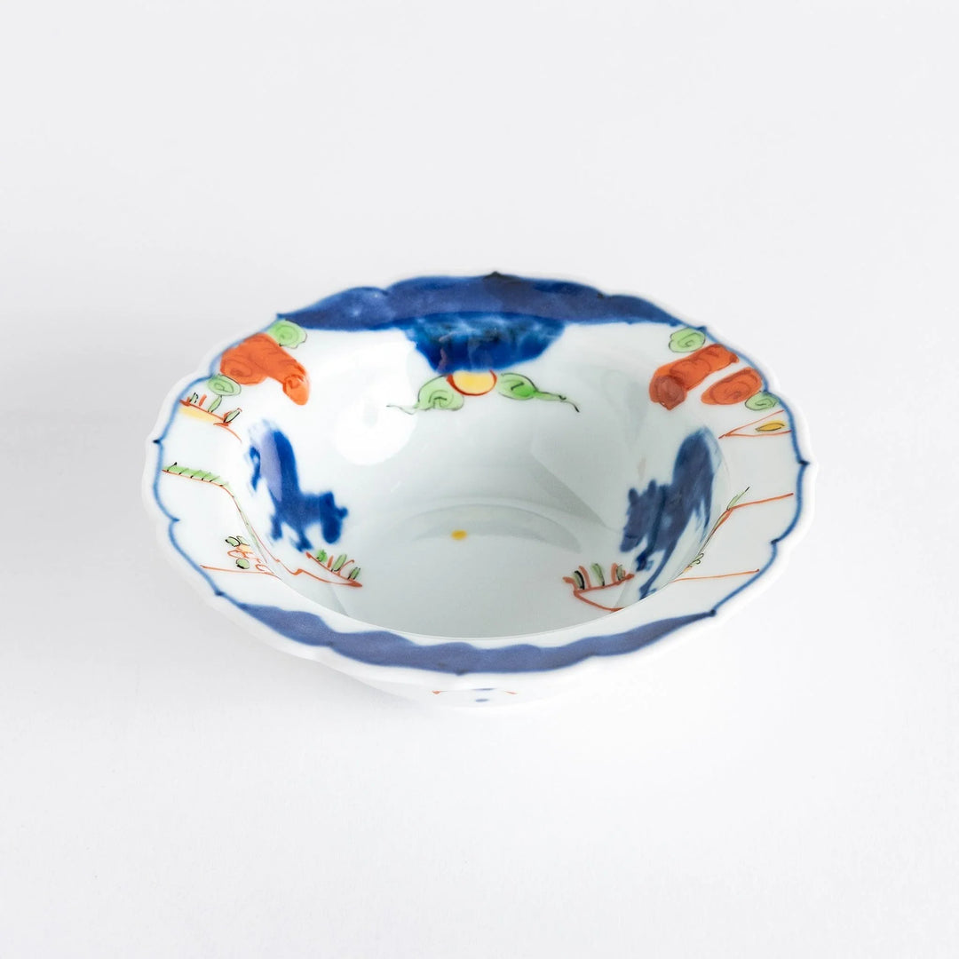 A small dessert bowl featuring colorful designs, including a galloping horse and abstract landscape motifs.