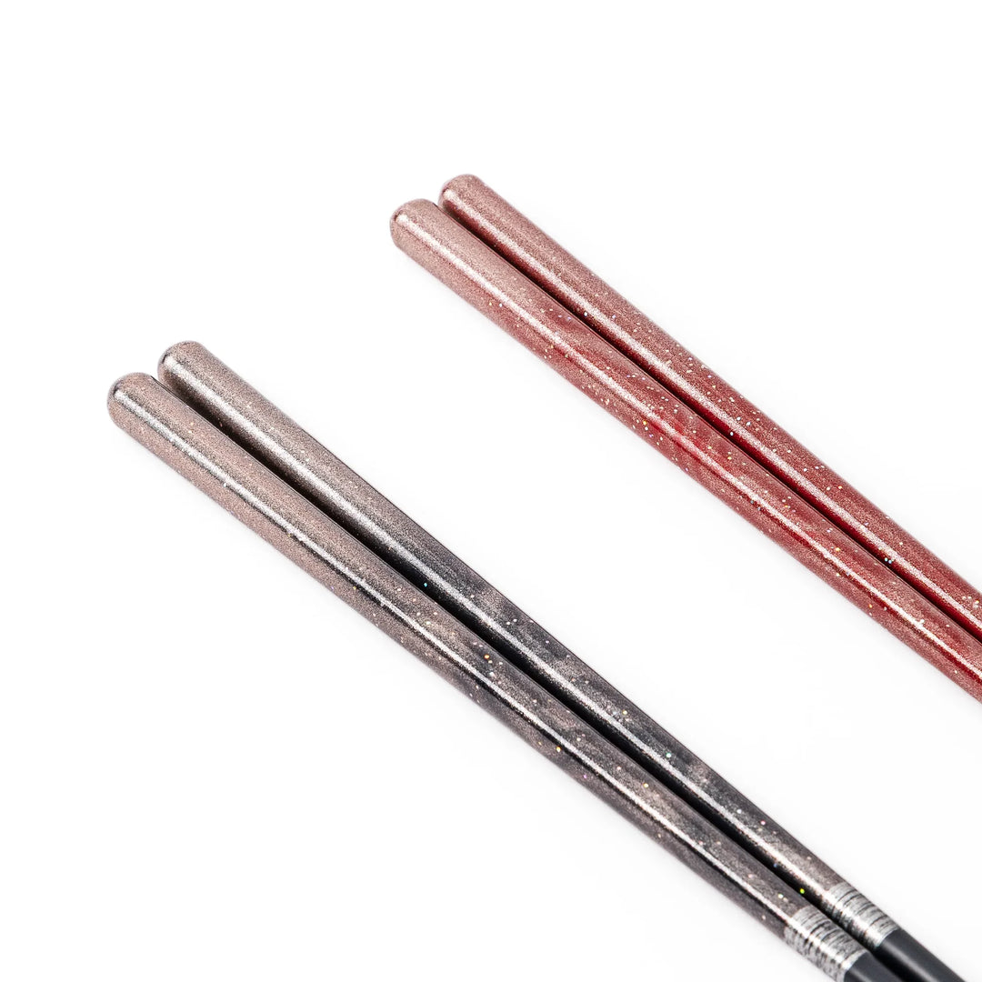 Close up of black and red Japanese lacquer chopsticks showing a beautiful sparkling glitter gradient finish on the handles