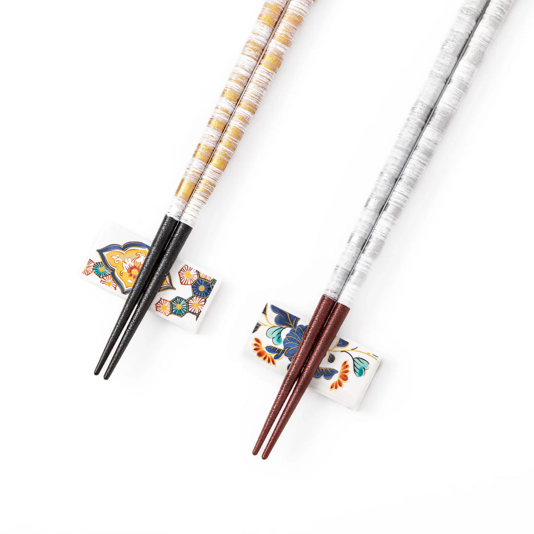 Close up of gold and silver Japanese chopsticks showing a beautiful textured metallic foil finish on a white background