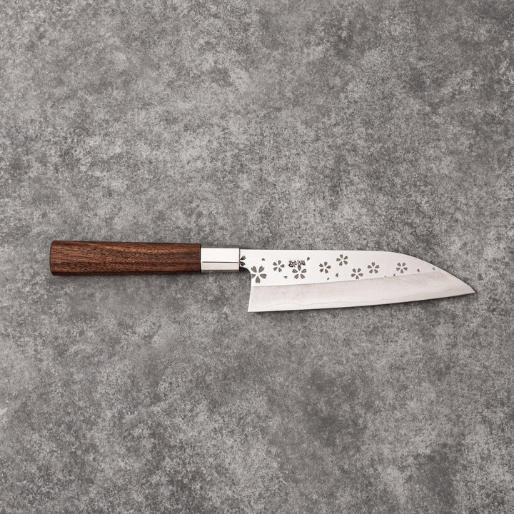 Japanese kitchen knife with cherry blossom cutout blade and dark wooden handle for precise cutting.