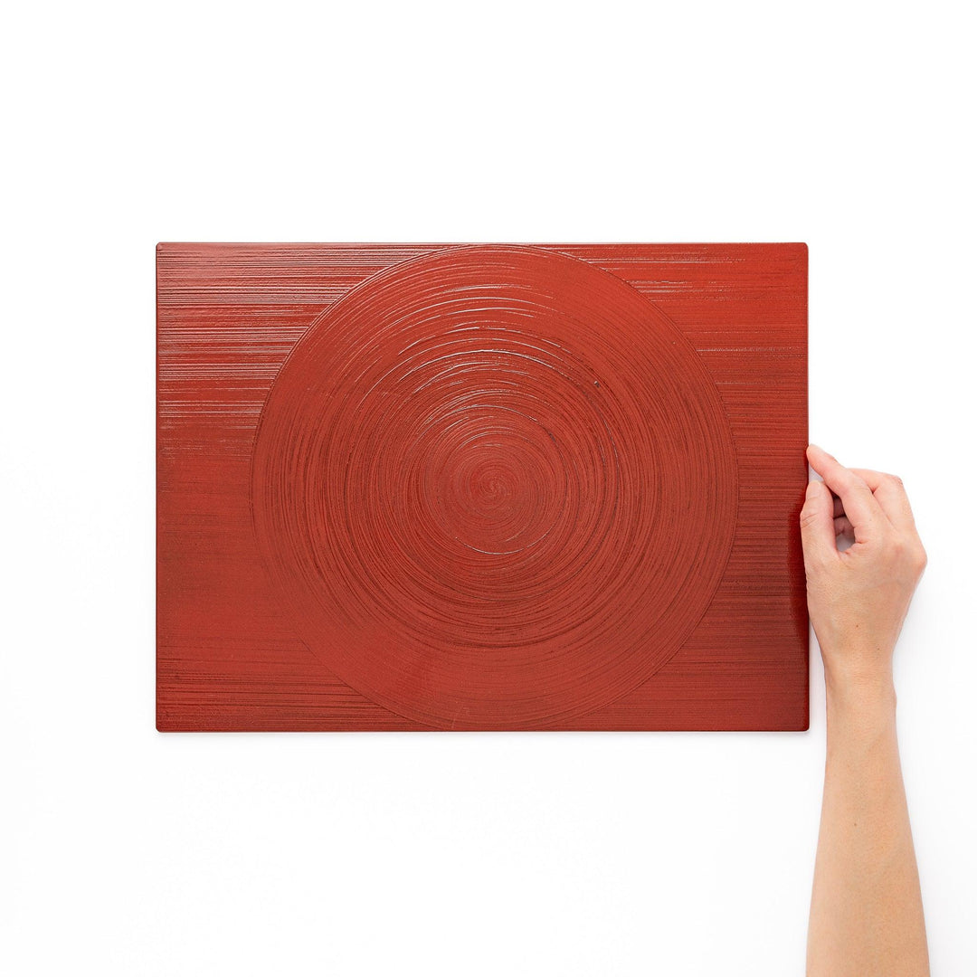 Reversible Japanese lacquer tray with circular brush texture in red and black for modern dining style.
