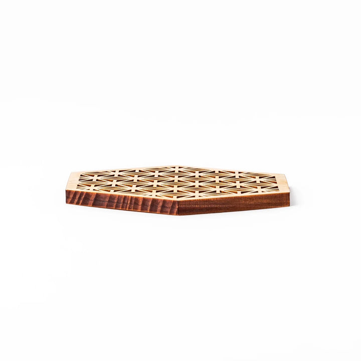 Hinoki wood coaster with a detailed hemp star cutout pattern in a hexagon shape against a white background.