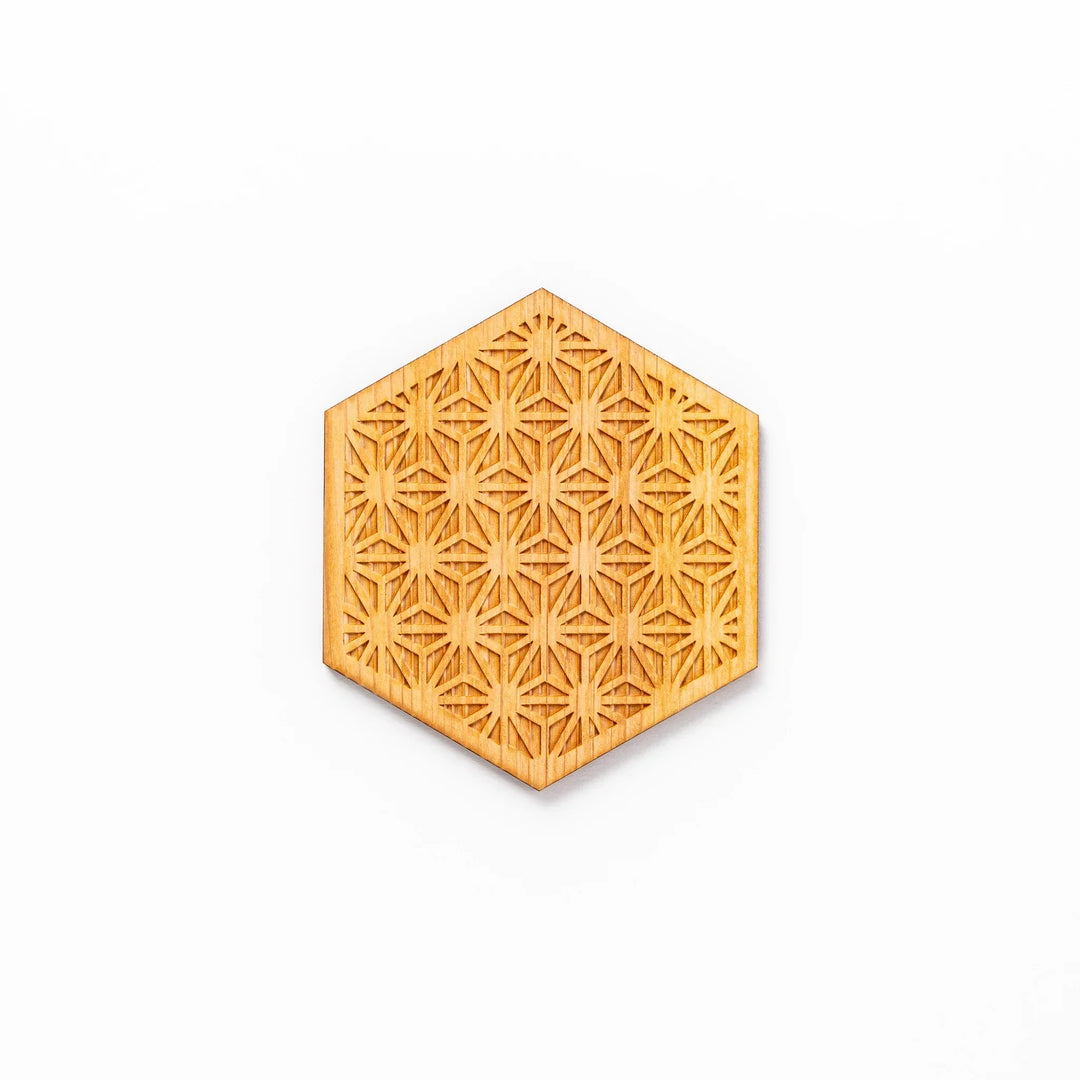 Hexagon hinoki wood coaster with engraved hemp star pattern on a white background.
