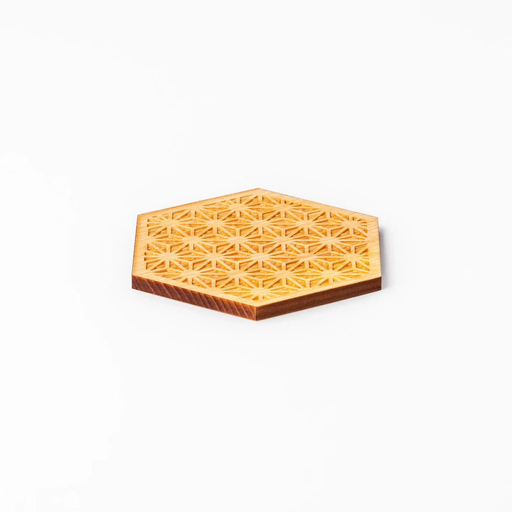 Hexagon hinoki wood coaster with engraved hemp star pattern on a white background.