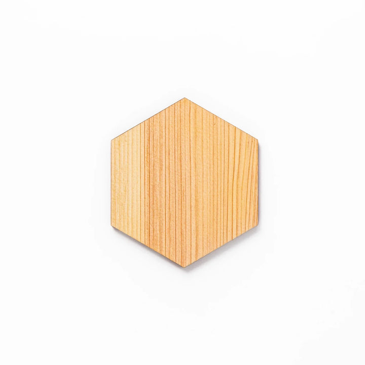 Hexagon hinoki wood coaster with engraved hemp star pattern on a white background.